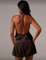 Vestido corto marrón con cuello halter y falda globo con cinturón con ojales y hebilla metálica.