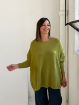 Sweater de punto color verde pistacho, con cuello redondo, mangas largas con puños ajustados y diseño holgado de corte oversize.
