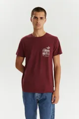 Remera de manga corta color bordó con cuello redondo. Presenta un estampado frontal en el pecho con el logo de la marca y un diseño gráfico de un jinete a caballo.