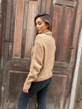 Sweater camel de punto trenzado con cuello alto.