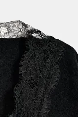 Jersey negro de manga larga con escote en V adornado con encaje negro.