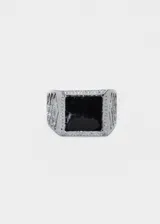 Anillo plateado de aleación de metales con piedra negra cuadrada en el centro.