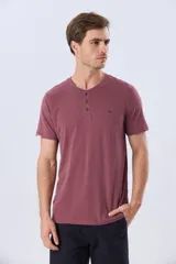Remera básica de manga corta y cuello redondo, color bordó, con cartera de botones en el pecho y pequeño bordado al tono.