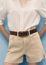 Short de jean de tiro medio, color beige, con diseño de cinco bolsillos, corte recto y bajo deshilachado.