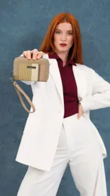 Billetera mediana con cierre perimetral, confeccionada en cuero sintético rosa y detalle central de tejido tipo telar con rayas verticales en amarillo, rosa y negro. Incluye correa de mano desmontable y placa metálica con logo de la marca.