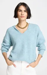 Sweater de punto en color celeste, con diseño de cuello en V y capucha integrada. Presenta mangas largas con puños acanalados y un corte holgado.