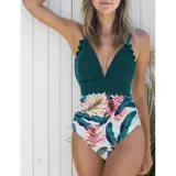 Malla enteriza con diseño combinado, parte superior en color verde petróleo con borde festoneado y parte inferior con estampado floral sobre fondo negro.