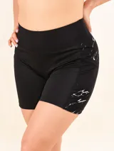 Calza corta deportiva de tiro alto, color negro, con paneles laterales estampados con diseño de mármol en blanco y negro.