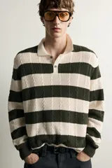 Sweater de punto a rayas horizontales en color verde oscuro y beige, con cuello polo y cierre frontal parcial con botones.