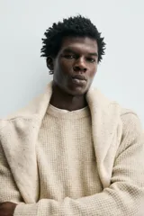 Sweater de punto color beige, de corte relajado, con cuello redondo y diseño texturizado en estructura waffle.