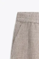 Pantalón de tiro alto color gris jaspeado, con cintura elástica y pernera ancha.