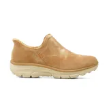 Bota casual tipo slip-on Skechers, confeccionada en gamuza color camel con tratamiento repelente. Presenta un diseño sin cordones con forro interior de chenilla suave y plantilla acolchada de espuma viscoelástica, montada sobre una suela de goma dentada en tono beige.
