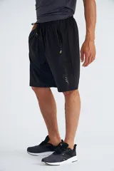 Short deportivo negro con cintura elástica ajustable con cordón, bolsillos laterales con cierre y detalles en verde flúor.