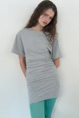 Vestido corto de algodón color negro, con cuello redondo, mangas cortas amplias y detalle de frunces elásticos laterales.