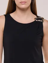 Musculosa azul de seda fría, con escote a la base y detalle de aplique metálico dorado en el hombro.