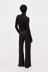 Pantalón de punto pesado color negro, de corte recto y acabado cepillado suave, con elástico revestido en la cintura y bolsillos parche delanteros con botón.