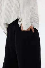 Pantalón de jogging de felpa de algodón pesado, con corte de pierna ancha y silueta relajada. Presenta cintura elástica con cordón ajustable, bolsillos laterales al bies y un bolsillo de parche en la parte trasera.