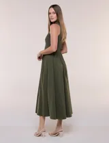 Vestido midi sin mangas de color verde militar, confeccionado con la parte superior en tejido de punto acanalado con cuello alto y falda acampanada de gran vuelo.