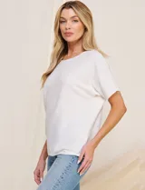 Buzo tejido de punto fino Allie Rose, color blanco, de silueta suelta y relajada con textura acanalada horizontal. Presenta escote redondo amplio, mangas cortas holgadas de corte caído y ruedo recto.