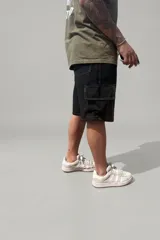 Bermuda cargo color negro No Basic, confeccionada en tela Stratus ligera con caída fluida. Cuenta con múltiples bolsillos laterales tipo cargo con solapa y costuras pespunteadas en contraste.