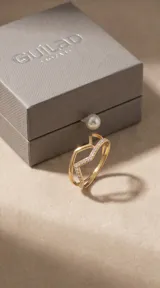 Anillo doble de acero con baño de oro, compuesto por una banda lisa y una banda en forma de V engastada con circonias.