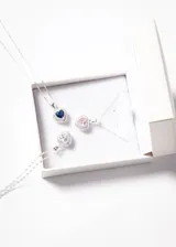 Collar de plata 925 con dije en forma de corazón con una zirconia azul central rodeada de pequeñas zirconias blancas.