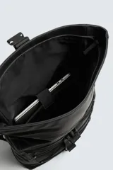 Mochila técnica de acabado engomado en color negro. Cuenta con cierre de solapa con hebilla de liberación rápida, compartimento interior para dispositivos electrónicos de hasta 13 pulgadas, bolsillo frontal plano, parte posterior acolchada con banda para equipaje, asa de mano y correas de hombro ajustables.