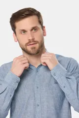Camisa de lino color beige con cuello mao, manga larga, cierre frontal de botones y bordado sutil en el pecho.