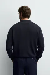 Polo de punto de manga larga confeccionado en lana italiana, con cuello solapa y cierre frontal de botones. Presenta puños y ruedo con acabado en rib.