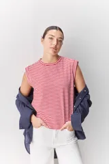 Remera sin mangas con diseño de rayas horizontales rojas y blancas, cuello redondo y hombros estructurados.