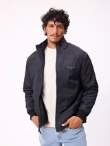 Campera reversible de sherpa y nylon, color negro, con cierre frontal, cuello alto y bolsillos frontales con solapa.