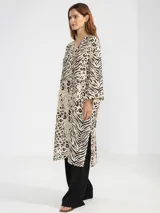 Camisa larga de lino 100% italiano, con estampado animal print que combina motivos de cebra y leopardo. Presenta un corte de estilo japonés, escote en V con tres botones delanteros y mangas tres cuartos anchas.