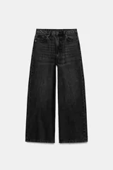 Jeans wide leg de tiro alto en denim negro con efecto lavado. Cuenta con cinco bolsillos tradicionales, trabillas para cinturón y cierre frontal con cremallera y botón metálico.