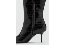 Bota alta de cuero sintético negro con textura efecto cocodrilo, punta fina y taco aguja fino.