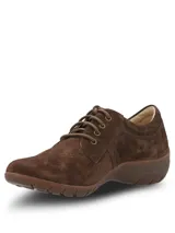 Zapato casual de mujer Hush Puppies modelo Rojam, confeccionado en cuero gamuzado color marrón. Presenta cierre mediante cordones al tono, suela de goma flexible y detalle de logo metálico en el lateral.