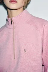 Sudadera de algodón color rosado con cuello alto, cierre frontal con cremallera metálica y manga larga. Presenta aplicación metálica en el pecho y acabados en rib.
