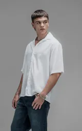 Camisa de manga corta con cuello cubano, corte oversize y cierre frontal de botones. Confeccionada en tejido de lyocell, presenta un diseño minimalista y liso.