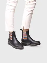 Botas de agua de caña baja color bordó, con elásticos laterales a rayas en tonos burdeos, beige y marrón. Cuenta con suela dentada negra, costuras blancas decorativas en el borde y presilla trasera para facilitar el calce.