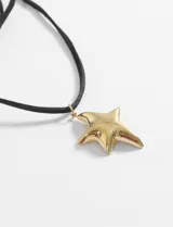 Gargantilla de cordón negro con dije de estrella dorada.
