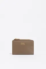 Billetera compacta de estructura blanda en color turquesa, con cierre de cremallera superior y logo metálico dorado en el frente.