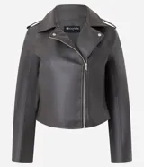 Campera estilo biker de poliuretano, con cierre frontal asimétrico, cuello con solapas y cremalleras en los puños. Presenta un diseño entallado con acabado liso.