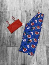 Conjunto de top corto rojo con tirantes finos y pantalón palazzo azul con estampado floral.