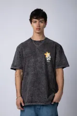 Remera de algodón con efecto acid wash en color gris oscuro. Presenta un diseño estampado en el pecho con una estrella amarilla y un personaje animado, y un corte semi-oversize.