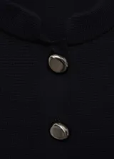 Chaqueta de punto fino color negro con cuello mao y cierre frontal de botones con efecto joya. Presenta un diseño recto y mangas largas.