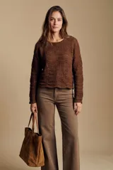Sweater oversize de tejido de punto color blanco con diseño calado de ondas y cuello redondo, de manga larga.