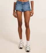 Short de jean azul con cierre frontal, trabillas en la cintura y detalle de cordones entrelazados en los laterales. Presenta un corte ajustado y acabado clásico.