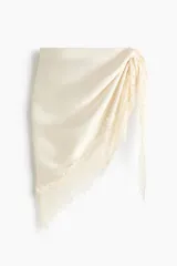 Pañuelo triangular grande confeccionado en tejido fluido de satén color beige, con delicado ribete de encaje en dos de sus lados.