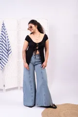 Blusa blanca de manga corta abullonada, con escote corazón y cierre frontal con múltiples lazos para atar.