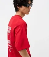 Remera de corte oversized color rojo, con cuello redondo y mangas cortas. Presenta un estampado gráfico en la espalda con el texto 'Innovation Research' y elementos de diseño técnico en color blanco.