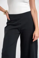 Pantalón negro de corte ancho y relajado, confeccionado en algodón texturizado.